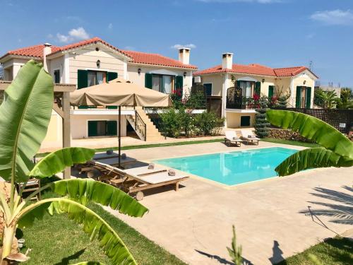 a villa with a swimming pool and a house at Dolce Vita Villas in Svoronata
