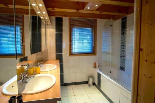 uma casa de banho com 2 lavatórios e uma banheira em Morgane Apartment em Chamonix-Mont-Blanc