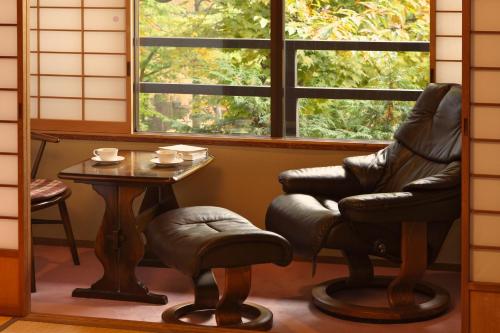 a chair and a table in a room at Tsuruya Ryokan in Karuizawa