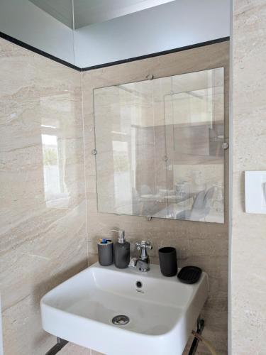 a bathroom with a white sink and a mirror at Clyford Suites in Bangalore