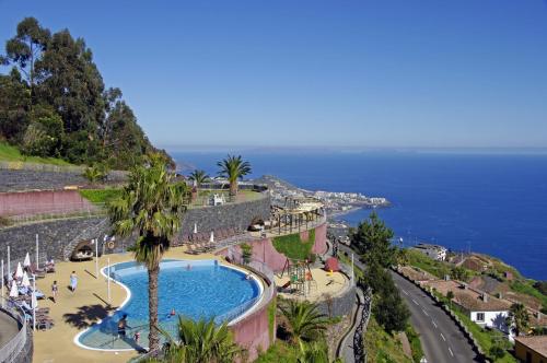 a view of a swimming pool next to the ocean at Village Cabo Girao in Câmara de Lobos
