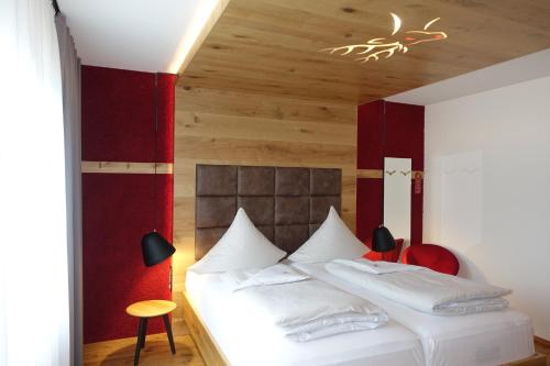 a bedroom with a bed with white pillows at Hotel Hirsch in Neu-Ulm