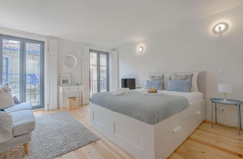 1 dormitorio blanco con 1 cama grande y 1 sofá en Downtown Porto Flat, en Oporto