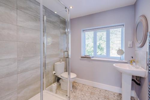 a bathroom with a shower and a toilet and a sink at Lymm Boutique Rooms in Lymm