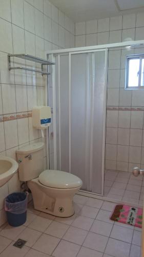 a bathroom with a toilet and a shower at Umin Chu Inn in Kenting