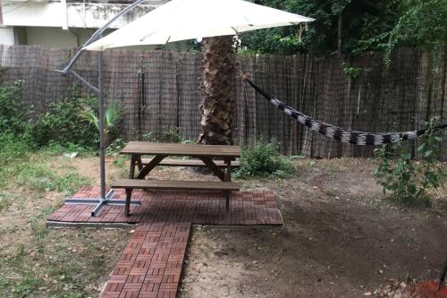 a picnic table with an umbrella in a backyard at Charmin apartment whit a big garden in Haifa