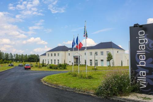 een groot wit gebouw met twee vlaggen ervoor bij Villa Bellagio Amboise by Popinns in Amboise