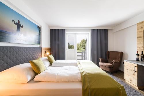 a bedroom with a large bed and a chair at OG's Golf Lodge in Kematen an der Krems