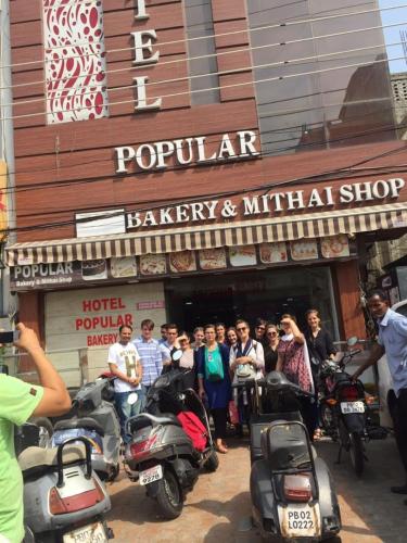 a group of people standing in front of a store with motorcycles at Hotel Popular in Amritsar