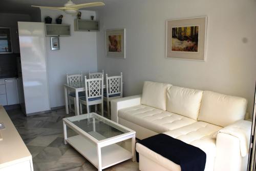 a living room with a white couch and a table at atico en Las Americas Islantilla primera línea de playa in Islantilla