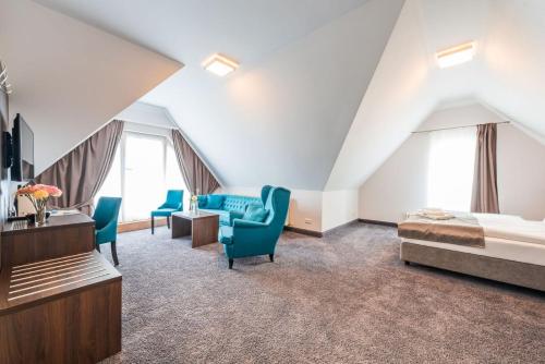 a bedroom with a bed and chairs in a attic at Hotel Villa Belvedere in Binz