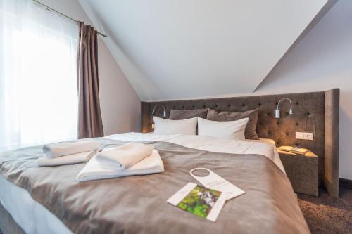 a bed with two towels and a book on it at Hotel Villa Belvedere in Binz