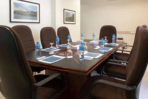 a conference room with a long wooden table and chairs at City Hotel Duqm in Duqm