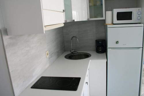 a small kitchen with a sink and a microwave at atico en Las Americas Islantilla primera línea de playa in Islantilla