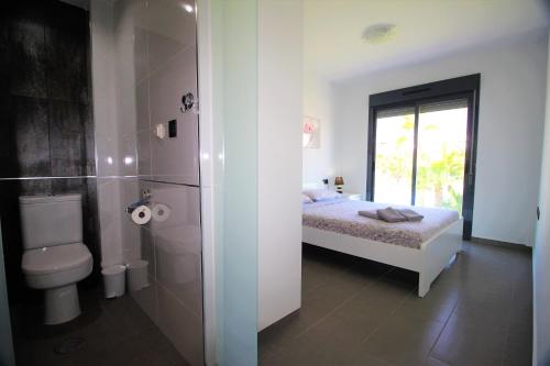 a bathroom with a bed and a toilet and a shower at Oasis Beach Gabriel in Orihuela Costa