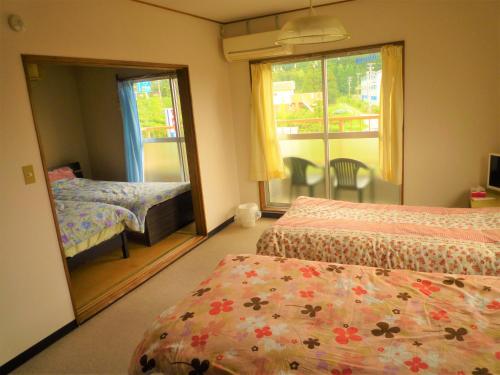 a bedroom with two beds and a window at Futami Terrace B in Ise