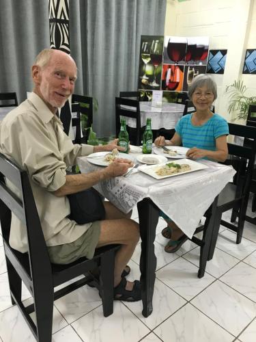 a man and a woman sitting at a table eating food at Moatoga Hotel in Apia