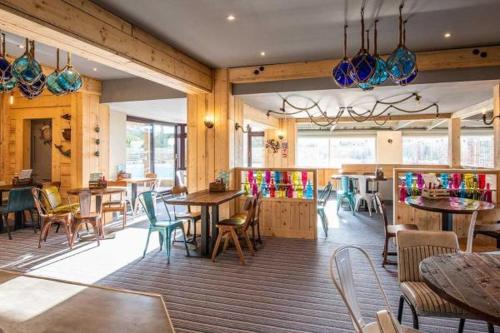 a restaurant with tables and chairs and colorful glasses at Whitecliff Bay Holiday Park in Bembridge