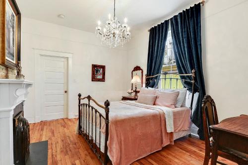 a bedroom with a bed and a chandelier at Elegant Renovated House With Relaxing Courtyard in New Orleans