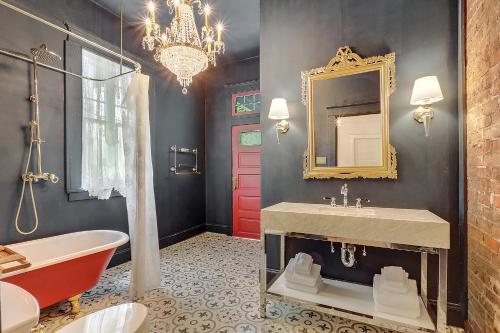 a bathroom with a chandelier and a red door at Elegant Renovated House With Relaxing Courtyard - Near FQ in New Orleans