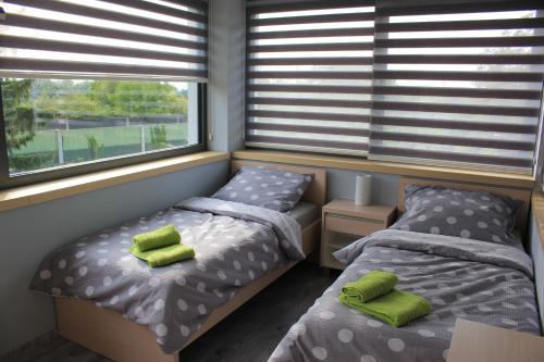 1 dormitorio con 2 camas y 2 ventanas en Apartments Severka en Praga