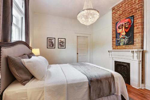 um quarto com uma cama e uma lareira em Modern Victorian House With Relaxing Courtyard em Nova Orleans