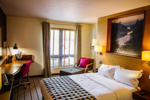 um quarto de hotel com uma cama, uma secretária e uma janela em Lodge at Bristol em Bristol