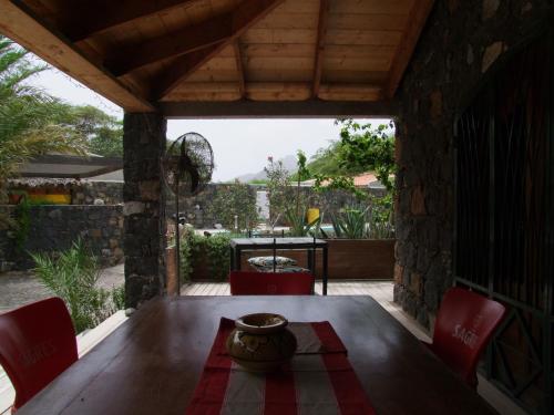 einen Holztisch mit Stühlen und eine Schüssel auf einem Tisch in der Unterkunft Villa Morabeza Guest House in Mindelo