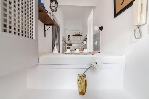 een witte kamer met een vaas met een bloem erin bij Sleep in the Clouds near Piazza Navona in Rome