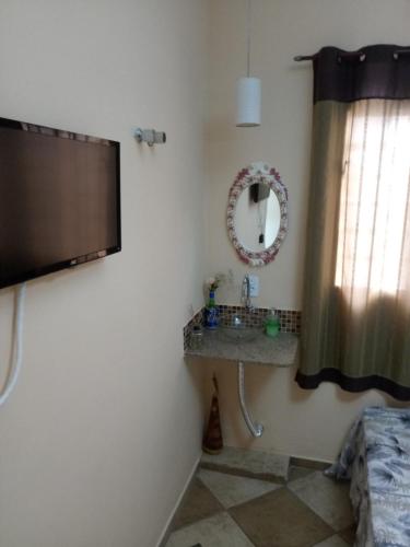 a bathroom with a flat screen tv on the wall at Casa de Hospedagem em Cachoeira Paulista in Cachoeira Paulista