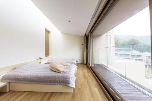 a bedroom with a bed and a large window at Healience Village in Hongcheon