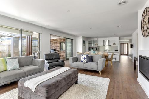 a living room with a couch and chairs and a kitchen at Luxury Capel Sound in Rye