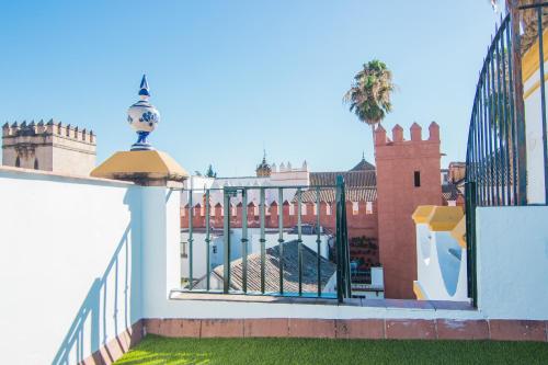 una valla blanca con una puerta y un edificio en Apartamentos Boutique Vida, en Sevilla