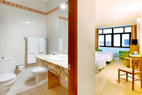 a bathroom with a sink and a toilet and a tub at Crisol Faycán in Las Palmas de Gran Canaria