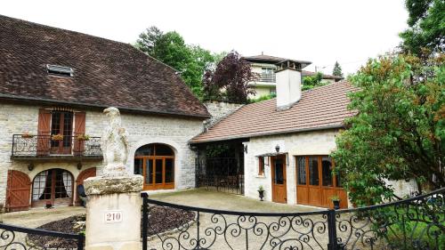a house with a fountain in front of a fence at Le vieux Pressoir in Saint-Germain-lès-Arlay