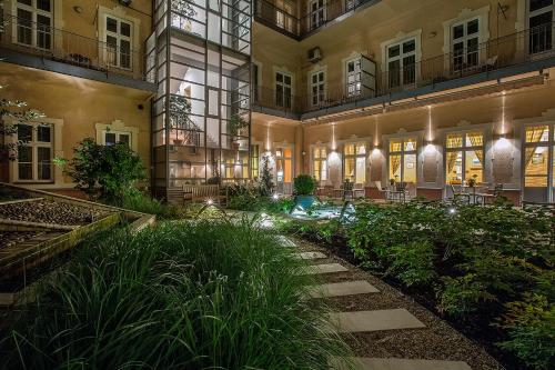 a courtyard of a building at night with plants at Mamaison Residence Izabella Budapest in Budapest