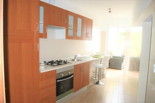 a kitchen with wooden cabinets and a stove top oven at Casa Amarela in Funchal