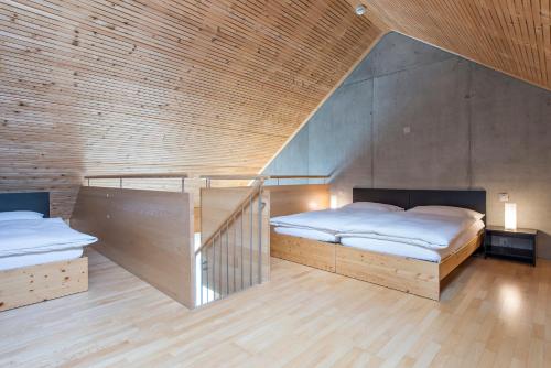 two beds in a room with wooden walls at All In One Hotel - Inn Lodge / Swiss Lodge in Celerina