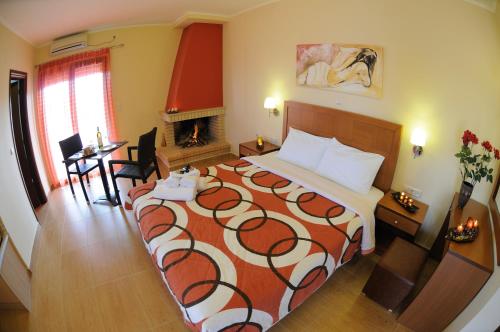 a hotel room with a bed and a fireplace at Faros Luxury Suites in Marathopolis
