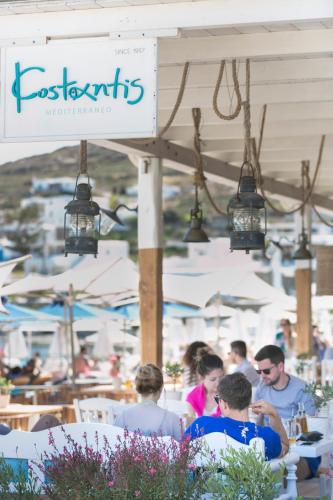 a group of people sitting in chairs at a restaurant at Kostantis Summer Villas and Suites in Ornos