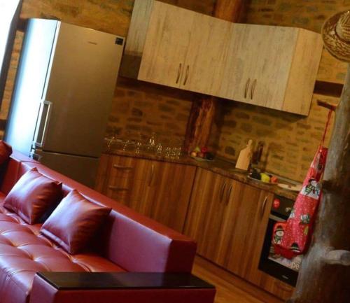 a living room with a red couch and a refrigerator at Dream house in Leshten