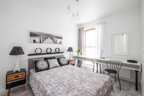 a white bedroom with a bed and a desk at Good Time Apartment Business Center in Warsaw