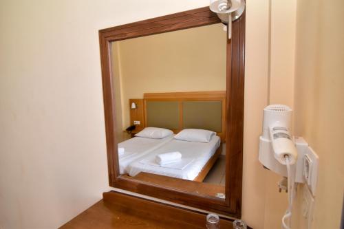 um espelho num quarto com uma cama e um telefone em Hermes Hotel em Kefalos