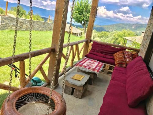 a porch with a couch and a swing at Dream house in Leshten