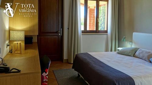 a bedroom with a large bed and a window at Tota Virginia Antico Podere in Serralunga d'Alba