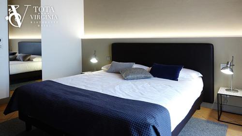 a bedroom with a large bed with two pillows on it at Tota Virginia Antico Podere in Serralunga d'Alba