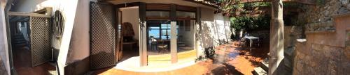 an outside view of a house with a glass door at Villa Velta Sea Sunset in Porto Santo Stefano