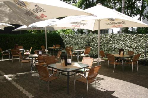 a table with chairs and umbrellas on a patio at Hotel Restaurant Balkan in Trier