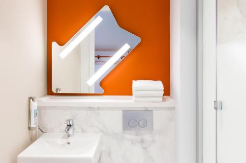a bathroom with a sink and a mirror at ibis budget Geneve Saint Genis Pouilly in Saint-Genis-Pouilly