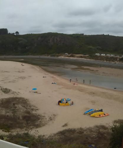 a beach with three boats on the sand at Mira-mar in Odeceixe